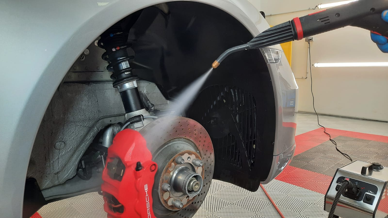 Nettoyage à la vapeur des trains roulants, des étriers de freins et des passages de roues plastiques avant application du traitement Céramic-Guard Etrier de freins et plastiques de passage de roues sur Porsche 911 Carrera 4 GTS Type 991